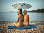 deux-femmes-nues-de-dos-sur-une-plage-de-gravier