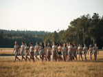 un-groupe-de-20-personnes-nues-marchent-dans-un-champ